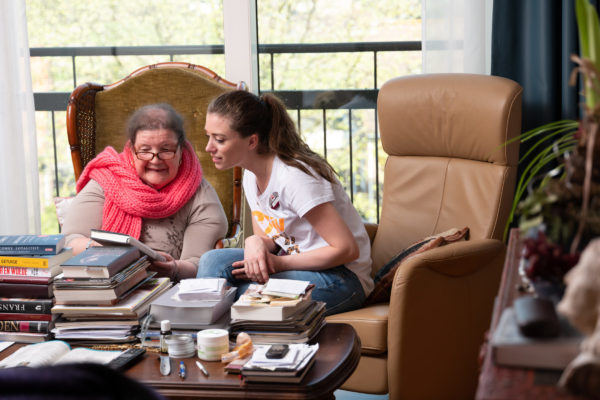 cliënt laat haar boeken zien aan de verzorgende