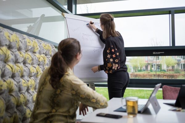 Twee medewerkers tijdens werkoverleg