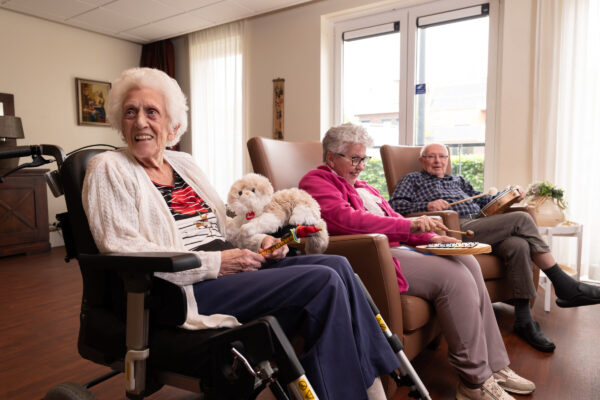 Drie cliënten in huiskamer tijdens maken van muziek