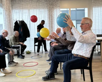 Cliënten doen oefening met bal en hoelahoep - Parkinsonisme