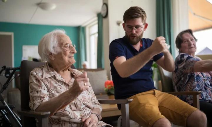 Medewerker en cliënt tijdens oefening met handen - Ergotherapie