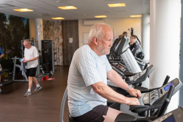 Cliënt aan het fietsen in de fitness - Seniorenfitness