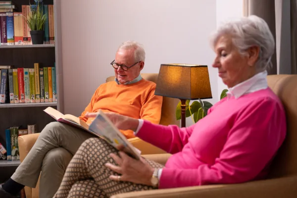 Bewoners zitten lezend naast elkaar - Thuiswonend