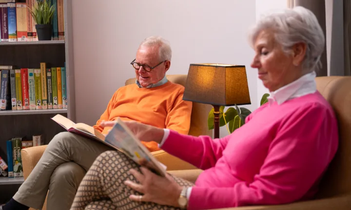 Bewoners zitten lezend naast elkaar - Thuiswonend