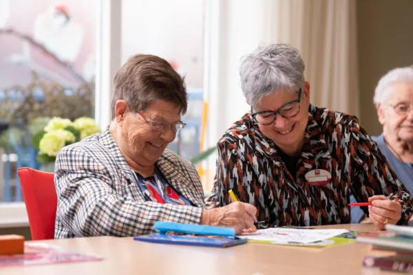 Cliënt en medewerker kleuren samen aan tafel - Zorgaanbod