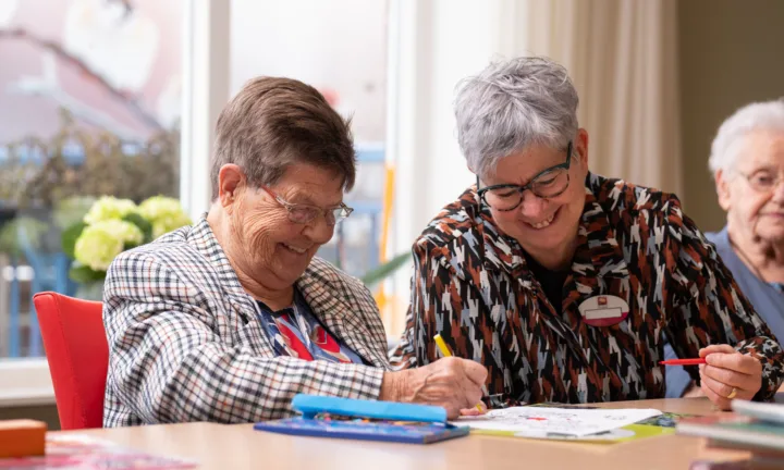 Cliënt en medewerker kleuren samen aan tafel - Zorgaanbod