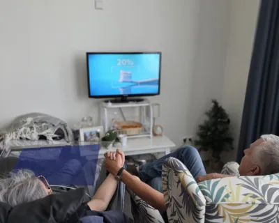 Foto dhr en mw Maassen hand in hand kijkend naar de tv - Verhalen